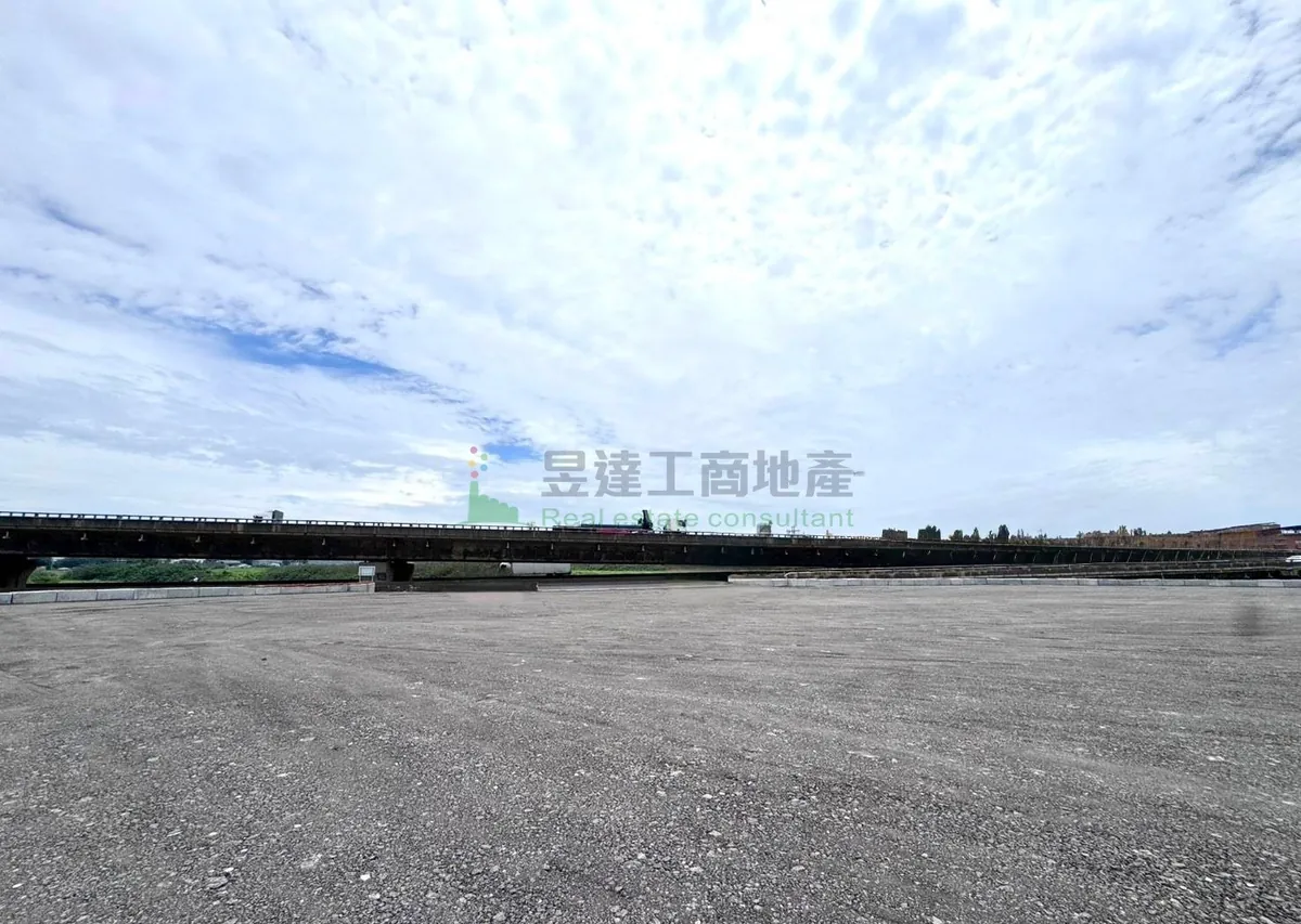 觀音交通用地現況:大面積整平的碎石地面,遠處橫過一段高架道路